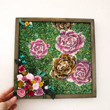 Load image into Gallery viewer, Decorative wall art with floral design in a wooden frame held by a hand on a white background.
