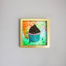 Load image into Gallery viewer, Framed artwork of a cupcake with colorful frosting on a gray wall.
