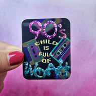 Sticker with '90s child is full of mood' text and cassette tape design held by a hand against a pink and purple gradient background.