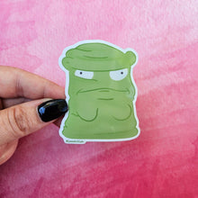 Load image into Gallery viewer, Green cartoon character sticker held by a hand against a pink watercolor background
