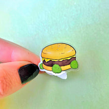 Load image into Gallery viewer, Sticker of a cartoon hamburger held between fingers against a light green background
