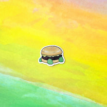 Load image into Gallery viewer, Cartoon hamburger sticker on a watercolor background with yellow and green colors

