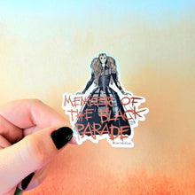 Load image into Gallery viewer, Sticker with a character in a black dress and text 'Member of the Black Parade' held by a hand against a gradient background.
