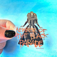 Sticker of a character in a black and white dress with 'Member of the Black Parade' text, held by a hand against a blue gradient background.