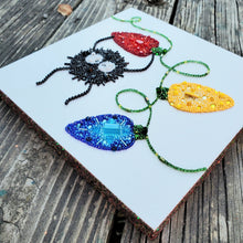 Load image into Gallery viewer, Beaded art piece on a wooden surface
