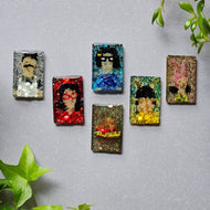 A set of six colorful hand-beaded refrigerator magnets featuring characters from the Bob's Burgers series, including the Belcher family and a burger, displayed on a grey background with green leaves in the bottom right corner.